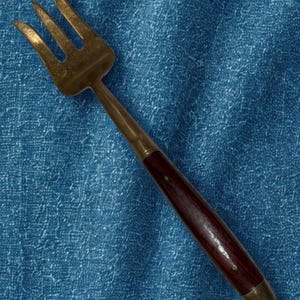 May include: A white ceramic mug with a black handle and the text "But First, Coffee" in a bold, black font. The mug is set against a blurred background, suggesting a cozy setting. The mug appears to be approximately 4 inches tall.