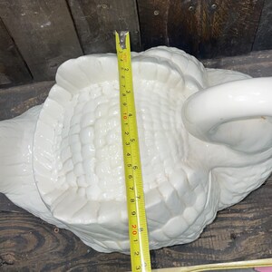 May include: White ceramic swan figurine with a textured surface. The swan is approximately 9 inches long.