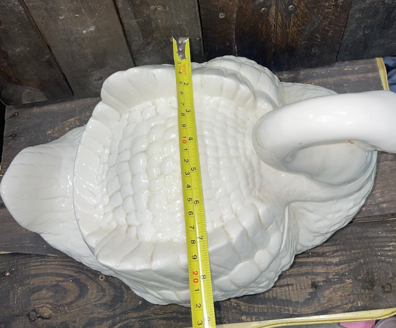 May include: White ceramic swan figurine with a textured surface. The swan is approximately 9 inches long.