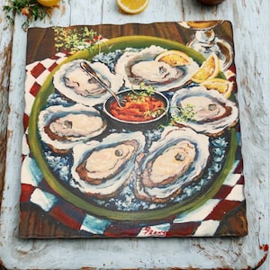 May include: A square ceramic serving platter featuring a painted illustration of oysters on a green plate with a small bowl of sauce. The platter is set on a checkered cloth with lemon slices.