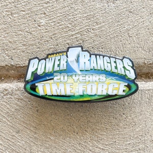 May include: A blue and yellow Power Rangers pin with the text "Saban's Power Rangers 20 Years Time Force".