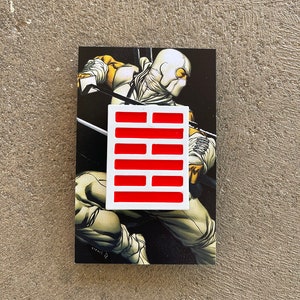 May include: White ninja figure with a red and white symbol on a black background.