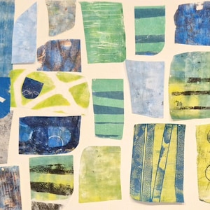 May include: A collage of various rectangular and irregular paper scraps featuring abstract patterns in shades of blue, green, and yellow. The pieces display diverse textures, including horizontal stripes, circular motifs, and layered ink washes.