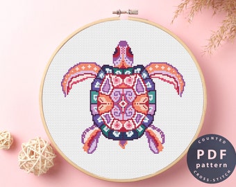 May include: A colorful cross-stitch pattern of a turtle with a mandala design. The pattern is in a wooden embroidery hoop and is ready to be stitched.
