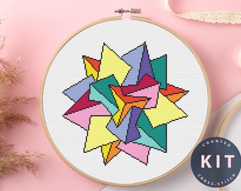 May include: A counted cross stitch kit featuring a colorful geometric design with a variety of shapes and colors. The design is in a circular shape and is surrounded by a white background. The kit includes all the materials needed to complete the project, including floss, fabric, and instructions. The kit is labeled "Counted Cross Stitch Kit".