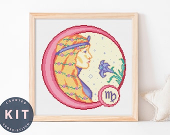 May include: A framed cross-stitch kit featuring a Virgo zodiac design. The artwork depicts a woman's profile within a pink circle, adorned with flowers and a blue headband. The kit includes the text "COUNTED KIT CROSS-STITCH".