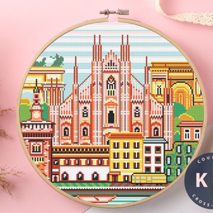 Puede incluir: Kit de punto de cruz contado con una ilustración pixelada colorida del Duomo di Milano, una famosa catedral de Milán, Italia. El kit incluye todos los materiales necesarios para completar el proyecto, incluyendo tela Aida, hilo de bordar y una aguja. El kit está etiquetado como "Counted Cross Stitch Kit".
