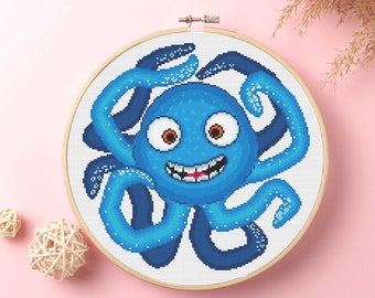 May include: A blue cartoon octopus with a big smile and one missing tooth. The octopus has a white background and is surrounded by a wooden embroidery hoop.