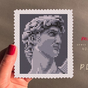 Może przedstawiać: Wzór haftu krzyżykowego w czerni i bieli przedstawiający twarz kobiety. Wzór ma 40 ściegów szerokości i 50 ściegów wysokości. Wzór jest oznaczony jako "mini haft krzyżykowy 40x50 PDF".