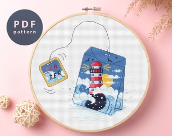May include: A cross-stitch pattern of a tea bag with a lighthouse and waves on it. The tea bag is labeled "Sea Tea".