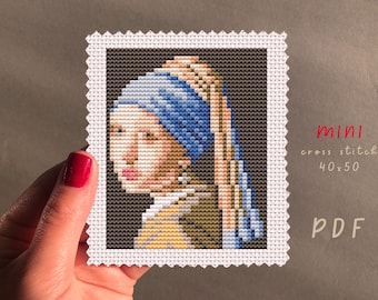 May include: A cross stitch pattern of the famous Girl with a Pearl Earring painting. The pattern is printed on white fabric and is framed with a white border. The pattern is 40 stitches wide by 50 stitches high. The pattern is labeled "mini cross stitch 40x50 PDF".