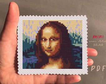 May include: A cross stitch pattern of the Mona Lisa, a famous painting by Leonardo da Vinci. The pattern is 50 stitches wide by 40 stitches high. The pattern is printed on white paper with a black border. The pattern is labeled "mini cross stitch 50x40 PDF".