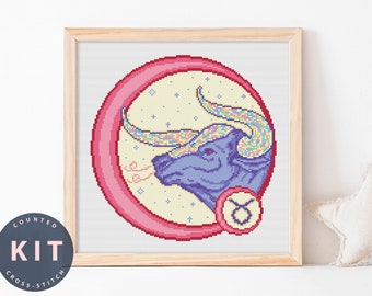May include: A counted cross stitch kit featuring a colorful bull with a pink circle around it. The bull is a zodiac symbol for Taurus. The kit includes a pattern and embroidery floss.