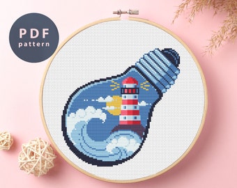 May include: A cross-stitch pattern featuring a lighthouse inside a lightbulb with blue waves and a yellow sun. The lightbulb is white with a silver top. The lighthouse is red and white with a black roof. The waves are blue and white. The sun is yellow. The pattern is on a white background.
