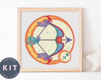 May include: A cross-stitch pattern featuring a colorful bow and arrow design with a yellow and orange background. The design is surrounded by a white border and includes the zodiac symbol for Sagittarius.