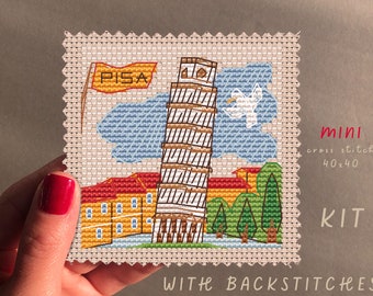 May include: A cross stitch kit featuring the Leaning Tower of Pisa, a yellow flag with the word "PISA" on it, and a white bird flying in the sky. The kit is 40x40 stitches and includes backstitches.