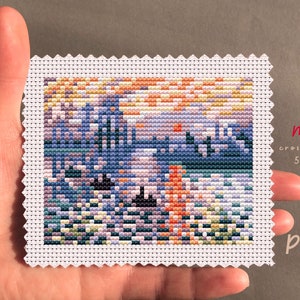 May include: A cross stitch pattern of a colorful sunset over a body of water with a small red sun and a few boats. The pattern is 50 stitches wide by 40 stitches high. The pattern is labeled "mini cross stitch 50x40 PDF".