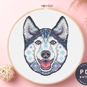 May include: A counted cross stitch pattern featuring a colourful husky dog with blue, white and black geometric patterns. The pattern is available as a PDF download.