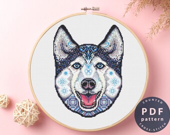 May include: A counted cross stitch pattern featuring a colorful husky dog with blue, white, and black geometric patterns. The pattern is available as a PDF download.