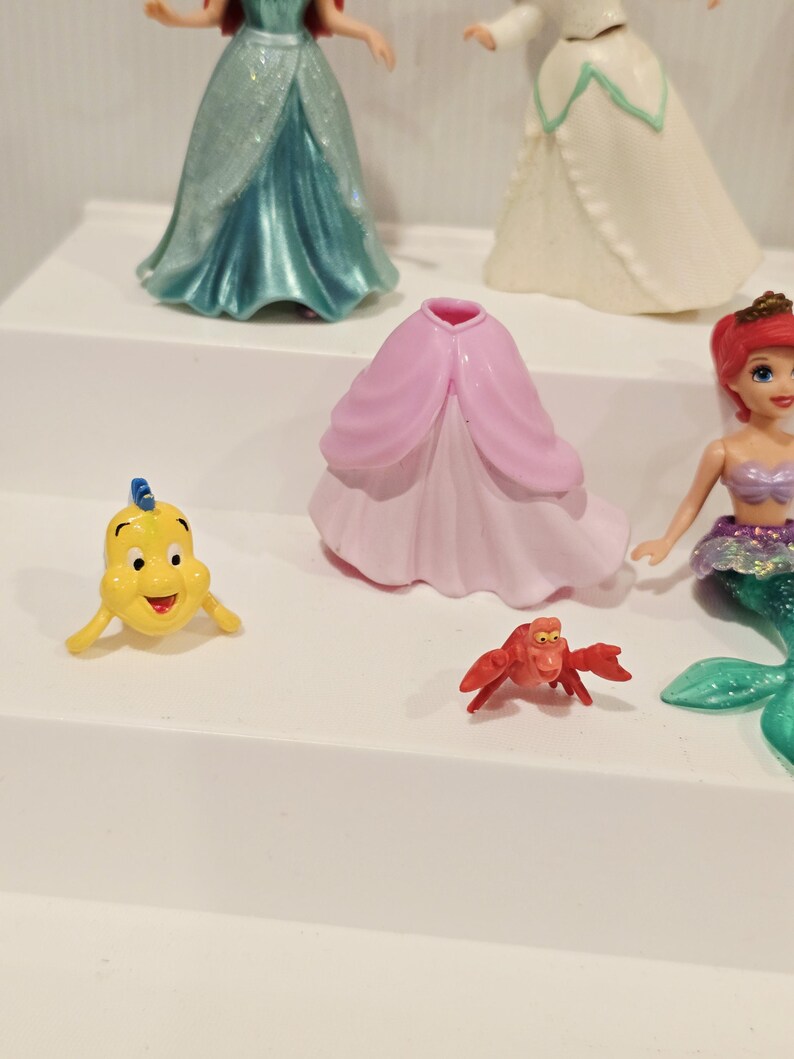 K&ouml;nnte beinhalten: Eine Sammlung von Disney-Figuren mit Charakteren aus Arielle, die Meerjungfrau. Die Figuren umfassen Arielle, Fabius, Sebastian und andere Charaktere. Die Figuren sind aus Kunststoff und farbenfroh.