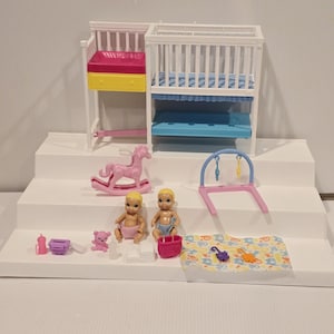 May include: A dollhouse nursery set featuring two cribs, a rocking horse, two baby dolls, and various accessories. The cribs are white with colorful accents. Accessories include a play mat, a baby swing, and a pink bucket. The set is designed for imaginative play.
