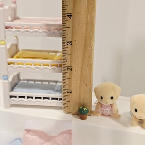 Puede incluir: Un juego de guarder&iacute;a en miniatura para casa de mu&ntilde;ecas con una litera triple, un peque&ntilde;o cachorro de peluche y otros accesorios. La litera mide aproximadamente 10 cm de alto. El juego incluye un pa&ntilde;al, una peque&ntilde;a planta en maceta y biberones.