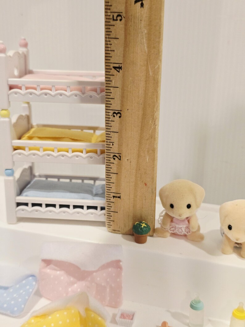 Puede incluir: Un juego de guarder&iacute;a en miniatura para casa de mu&ntilde;ecas con una litera triple, un peque&ntilde;o cachorro de peluche y otros accesorios. La litera mide aproximadamente 10 cm de alto. El juego incluye un pa&ntilde;al, una peque&ntilde;a planta en maceta y biberones.