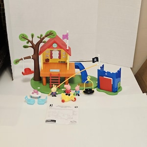 May include: A Peppa Pig treehouse playset featuring a red roof, a brown tree with a red swing, a blue slide, and a blue castle structure with a black pirate flag. Includes three pig figures, a yellow tricycle, a table, two chairs, and a tire swing.