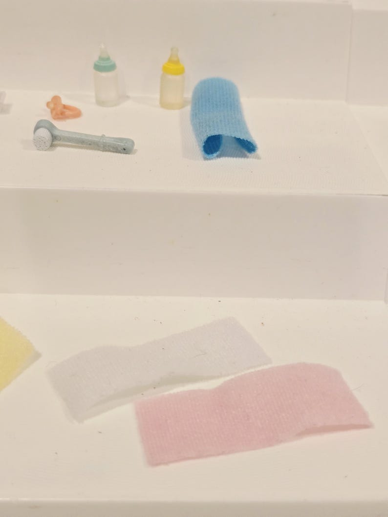 Puede incluir: Colecci&oacute;n de art&iacute;culos para el cuidado del beb&eacute;, que incluye dos biberones, un cepillo de dientes de dedo azul, un mordedor y tres manoplas para dedos en blanco, rosa y amarillo. Los biberones tienen tapas de colores.