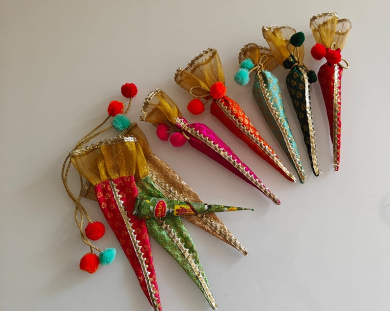 May include: A set of seven colorful cone-shaped pouches with gold trim and tassels. The pouches are made of fabric and have a variety of patterns.