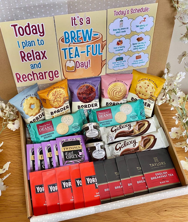 May include: A gift box containing Border biscuits, Dean's shortbread rounds, two Galaxy chocolate bars, two small jars of preserves, Twinings Earl Grey tea bags, Yorkshire tea bags, and Taylors English Breakfast tea bags with three decorative cards.