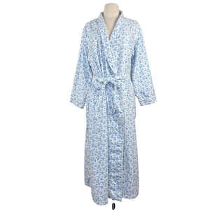 May include: A long, light blue floral print robe with a matching tie belt. The robe features a wrap-around design and is displayed on a mannequin. The floral pattern consists of small blue flowers on a white background.