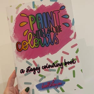 May include: A coloring book titled "Paint with All the Colours" with a pink and colorful design. The cover features the text in rainbow colors, with a pink background and colorful confetti-like shapes. The words "a stagey colouring book" are also on the cover.