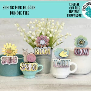 May include: A set of five spring-themed mug huggers, each with a different design and text. The designs include a flower, a snail, a bird, and two different versions of the word "spring". The text on the mug huggers includes the words "bloom", "grow", "tweet", and "spring".