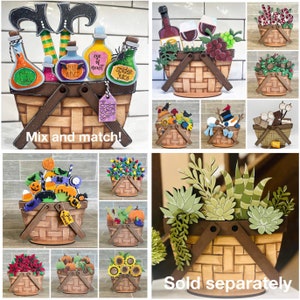 May include: A collection of wooden basket crafts with various themes, including Halloween, Christmas, and nature. Each basket is decorated with different elements, such as pumpkins, candy canes, and succulents. The baskets are sold separately. "Mix and match!" and "Sold separately" text is included in the image.