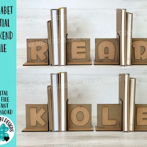 May include: A set of two wooden bookends featuring the letters "READ" and "KOLE" in a brown color. The bookends are designed to look like individual blocks with rounded edges. The letters are cut out of the blocks, creating a unique and decorative design.