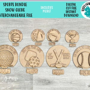 May include: A set of 10 wooden snow globe inserts featuring sports-themed designs. The designs include a basketball, a golf ball, a baseball, a football, a hockey stick and puck, a softball, a lacrosse stick and ball, a cheerleader's megaphone, a trophy, and a golf club. Each design has a phrase associated with the sport, such as "Play Hard or Go Home", "I'd Rather Be Golfing", "Softball is My Favorite Season", "Eat Sleep Hockey Repeat", and "Just One More Game".