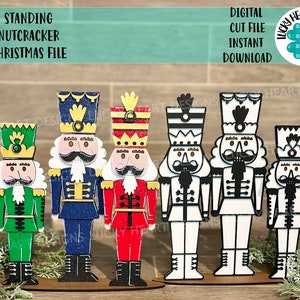 May include: Five wooden nutcracker figurines standing in a row on a wooden base. The nutcrackers are painted in different colors, including green, blue, red, black, and white. They are all wearing traditional nutcracker costumes with hats and beards. The nutcrackers are a popular Christmas decoration.