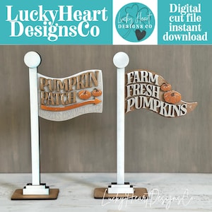 May include: Two decorative flag signs on white poles with rectangular bases. The left flag reads PUMPKIN PATCH with an arrow and text HAYRIDES, CORN MAZE, CIDER. The right flag reads FARM FRESH PUMPKINS with small orange pumpkin illustrations.