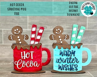 May include: Two wooden hot cocoa mugs, one red and one blue, each with a gingerbread man and candy sticks. The red mug says "Hot Cocoa," and the blue mug says "Warm Winter Wishes." A digital cut file is available.