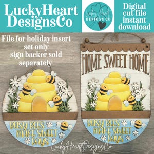 May include: Two wooden signs with a bee theme. One is round and the other is rectangular. Both signs feature a yellow beehive, bees, and the phrase "Busy Bees Make Sweet Days." The round sign has the text "Lucky Heart Designs Co."