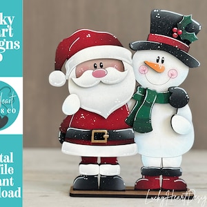 May include: A wooden cutout featuring Santa Claus in a red suit with a black belt and a snowman wearing a black top hat with holly and a green scarf. The text Lucky Heart Designs Co Digital cut file instant download is visible.