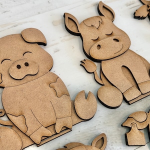 Puede incluir: Un conjunto de tres recortes de animales de madera, que incluyen un cerdo, un burro y una vaca. Los recortes est&aacute;n sin terminar y listos para ser pintados o decorados.