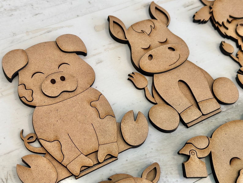 Puede incluir: Un conjunto de tres recortes de animales de madera, que incluyen un cerdo, un burro y una vaca. Los recortes est&aacute;n sin terminar y listos para ser pintados o decorados.
