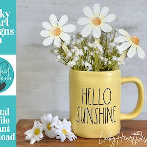 May include: A yellow mug with the words "HELLO SUNSHINE" holds white flowers and wooden daisy decorations. The image includes the text "Lucky Heart Designs Co" and "Digital cut file instant download".