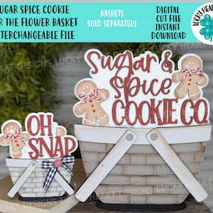Può includere: Un ritaglio di legno di un uomo di pan di zenzero che tiene un cestino con il testo "Sugar & Spice Cookie Co." e un ritaglio più piccolo di un uomo di pan di zenzero che tiene un cestino con il testo "Oh Snap".