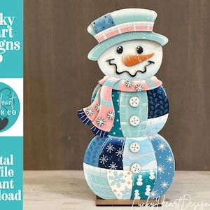 May include: A decorative snowman cutout featuring a patchwork design in shades of blue, white, and pink. The snowman wears a top hat and a scarf adorned with snowflake patterns and four white buttons. Text on the left reads Lucky Heart Designs Co.