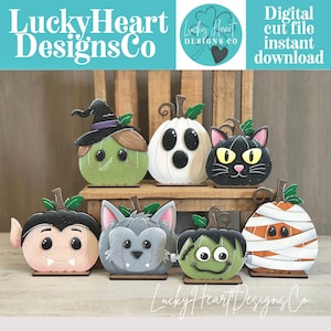 May include: A set of seven decorative wooden pumpkin cutouts featuring Halloween characters including a witch, ghost, black cat, vampire, werewolf, Frankenstein monster, and mummy. Each pumpkin has a green stem and a flat base for standing.