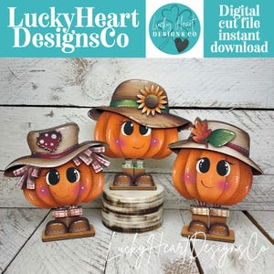 May include: Three orange pumpkin figures with smiling faces, rosy cheeks, and brown boots. Each wears a hat: one with a sunflower, one with a red mushroom patch, and one with a leaf. The text LuckyHeartDesignsCo and Digital cut file instant download appears.