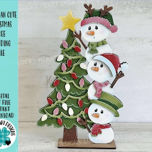 May include: A wooden Christmas decoration featuring a snowman design. The snowman is stacked with three snowmen wearing hats and scarves, and a Christmas tree with lights. The text "SNOWMAN CUTE CHRISTMAS TREE STANDING FILE" is visible.